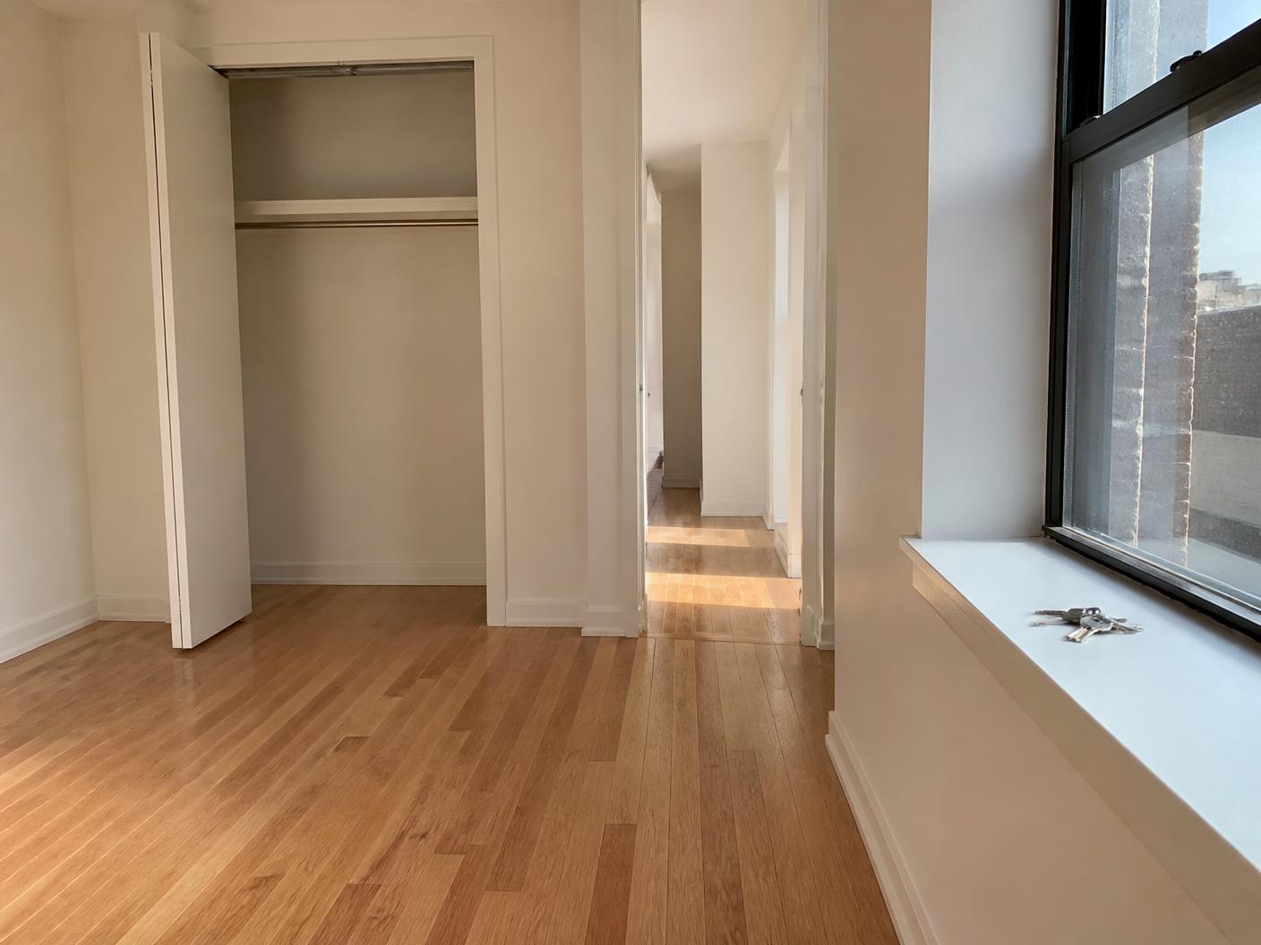 Empty apartment cleaned for handover with bare floors and keys on the windowsill